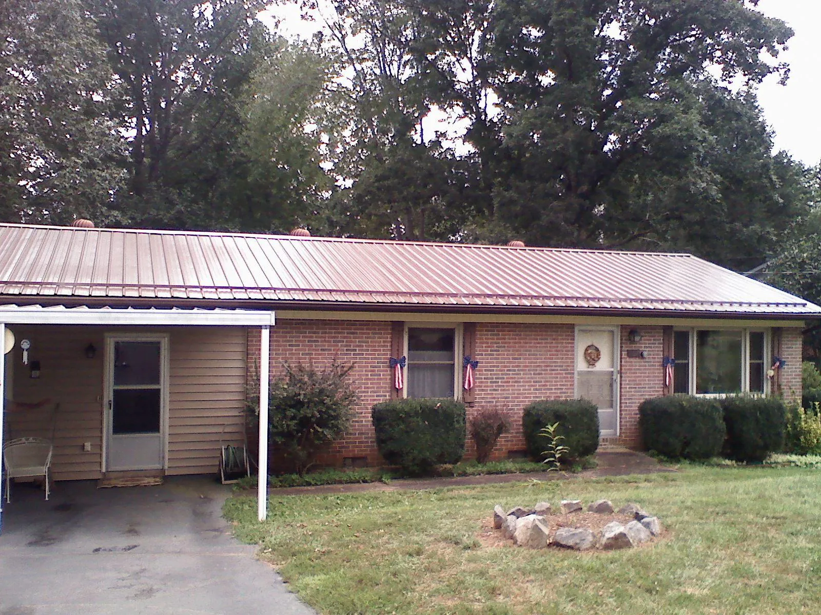 Bronze metal roof and carport on a brick ranch home — Roof Repair work by our crew in Windham